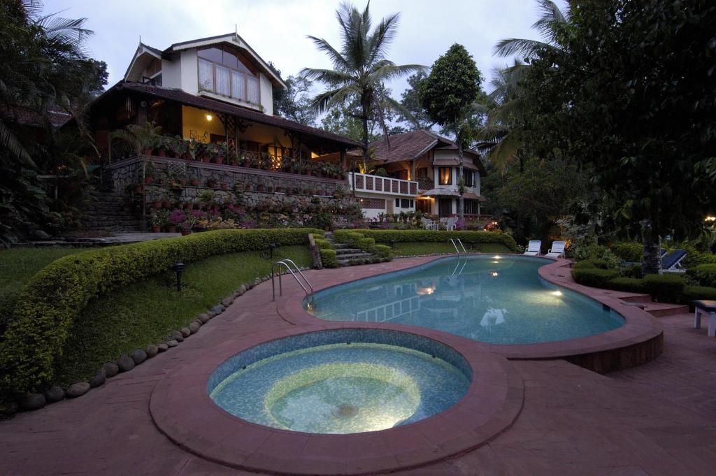 安巴拉瓦亚尔Tranquil Resort - Blusalzz Collection, Wayanad - Kerala的房屋前有游泳池的房子