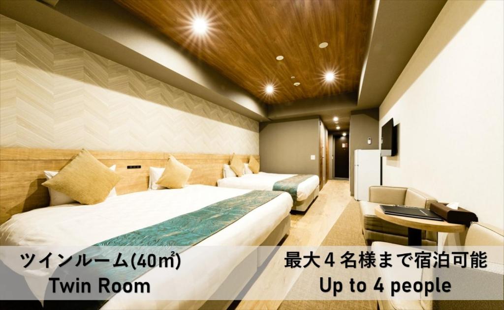 大阪Takuto Hotel Osaka Shinsaibashi的酒店客房,设有两张床和一张沙发
