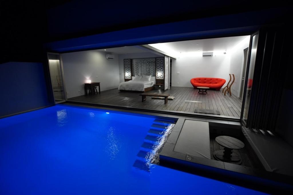 备濑Secret Pool villa Seji的一个带游泳池、一张床和一张沙发的房间