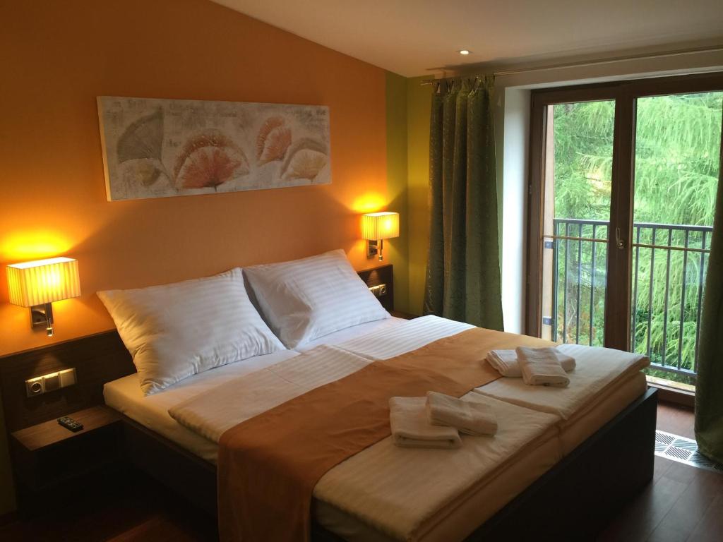 斯特拉日尼Casino & Hotel Admiral Strážný的一间卧室配有一张大床和两条毛巾