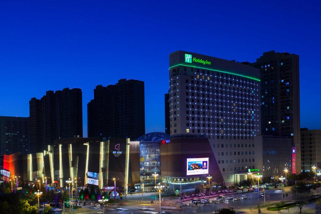 盘锦盘锦水游城假日酒店的一座大建筑,晚上有标志
