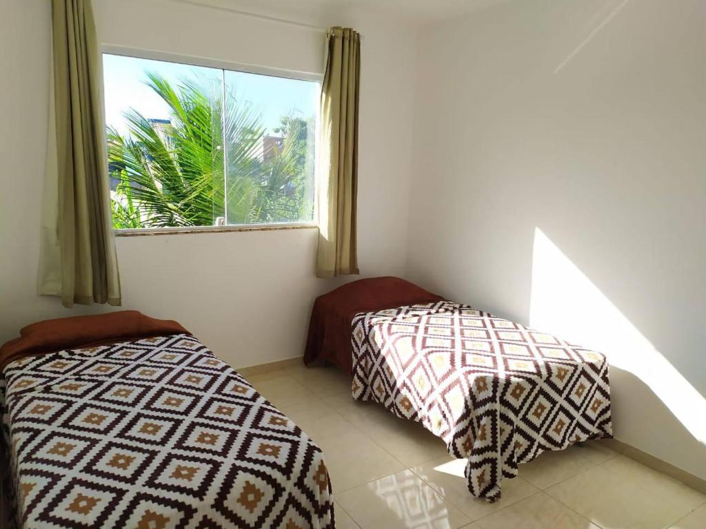 瓜拉派瑞Casa na praia d’Ulé的带窗户的客房内的两张床