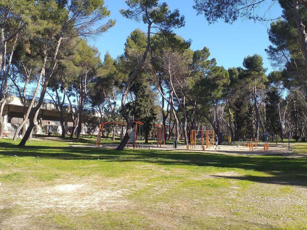 马德里Homenfun Madrid Villaverde Bajo的公园里设有种有树木和草地的游乐场