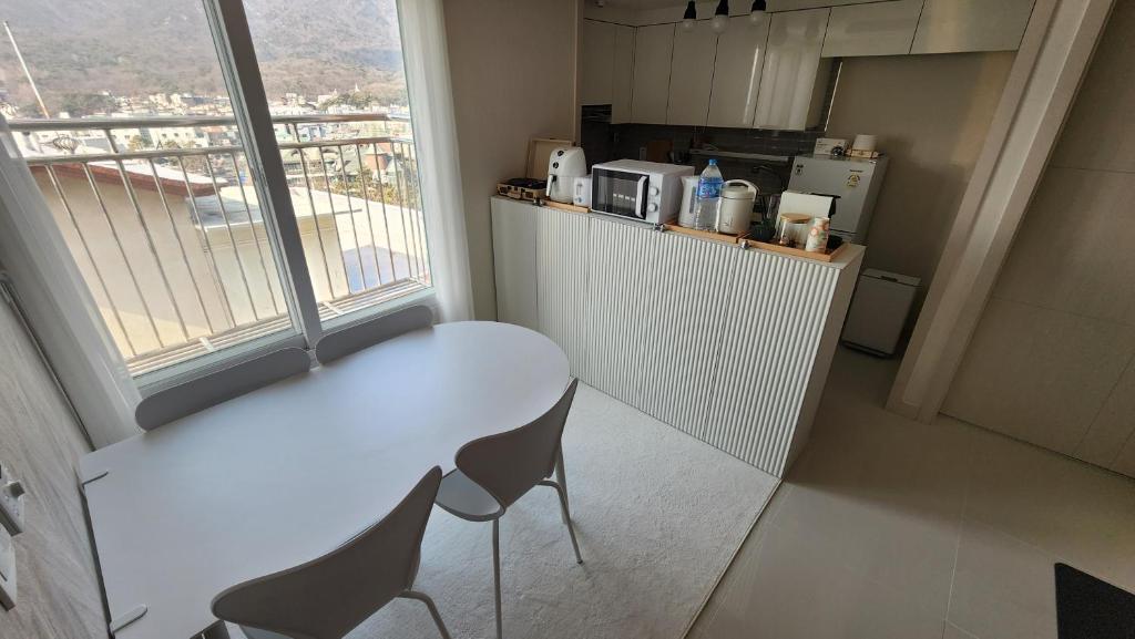 首尔lI - Full option two-room mountain view private house的窗户客房内的白色桌椅
