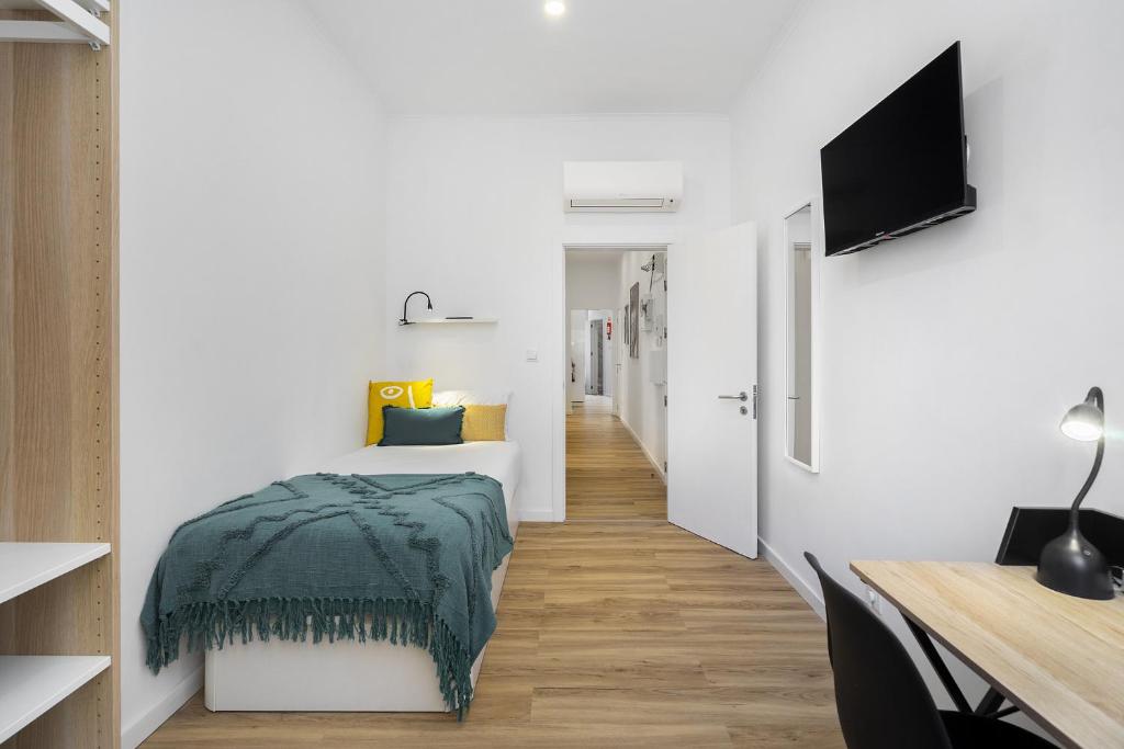 里斯本Smart Living Hub: Designer Spaces for Digital Nomads & Remote Workers的一间卧室配有一张带绿毯的床