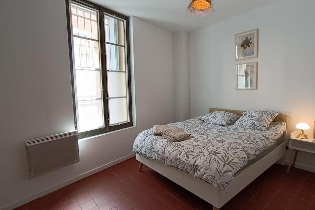 佩皮尼昂hypercentre, appartement coquet en rez-de-chaussée的白色的卧室设有床和窗户