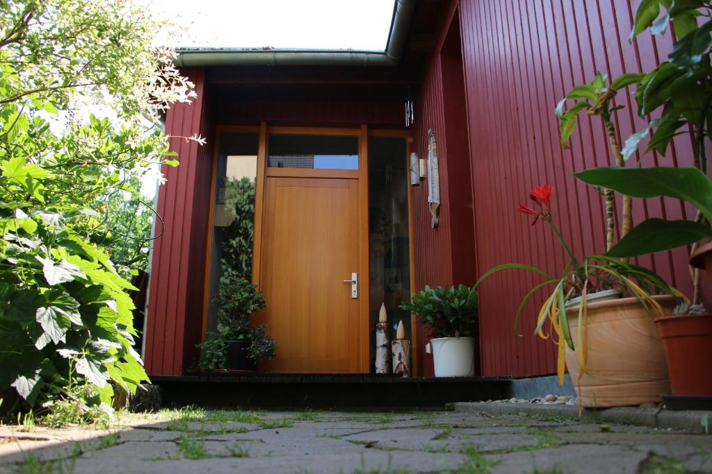 德累斯顿克罗兹施花园公寓的一间红色的房子,有棕色的门和一些植物