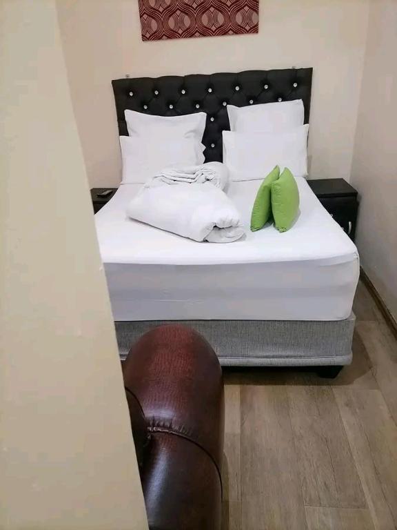 梅富根Rizhatchguest的一张带两个绿色枕头的白色床