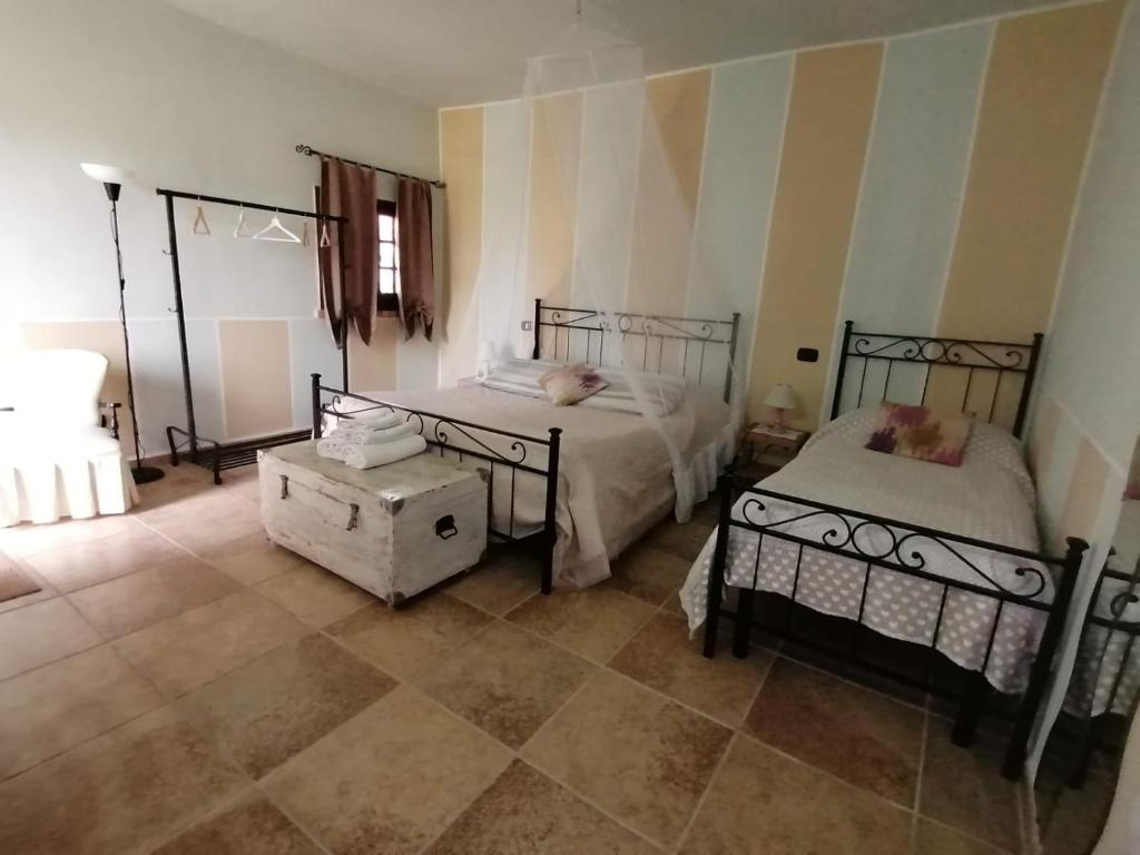 塞尔莫内塔Casale Cavatella的一间带两张床的卧室,铺有瓷砖地板。
