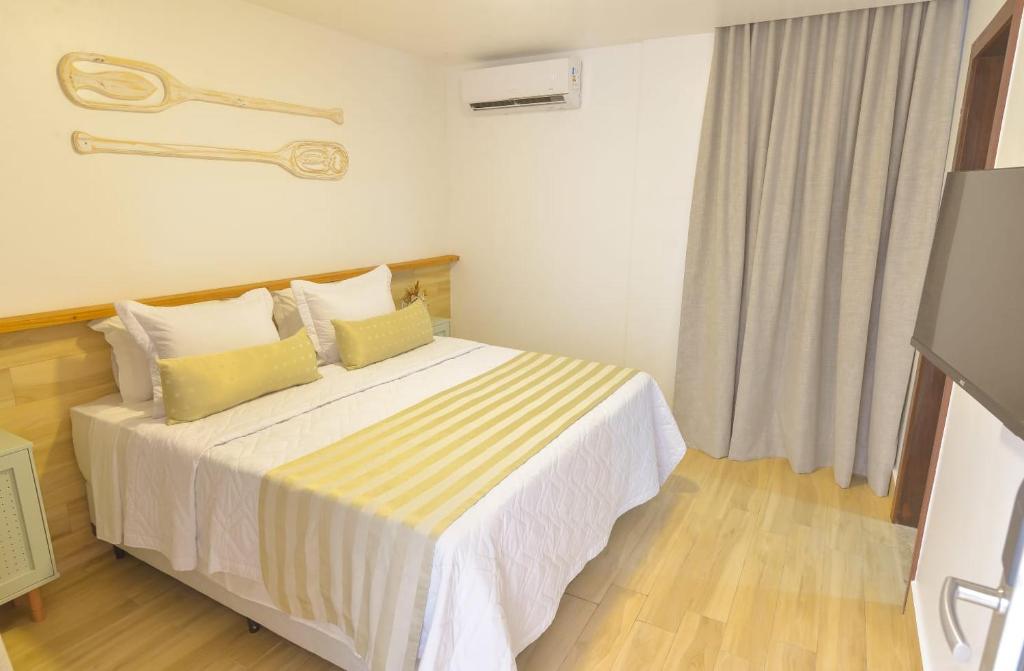莫罗圣保罗Topázio Pousada的一间卧室配有一张带黄色枕头的大床
