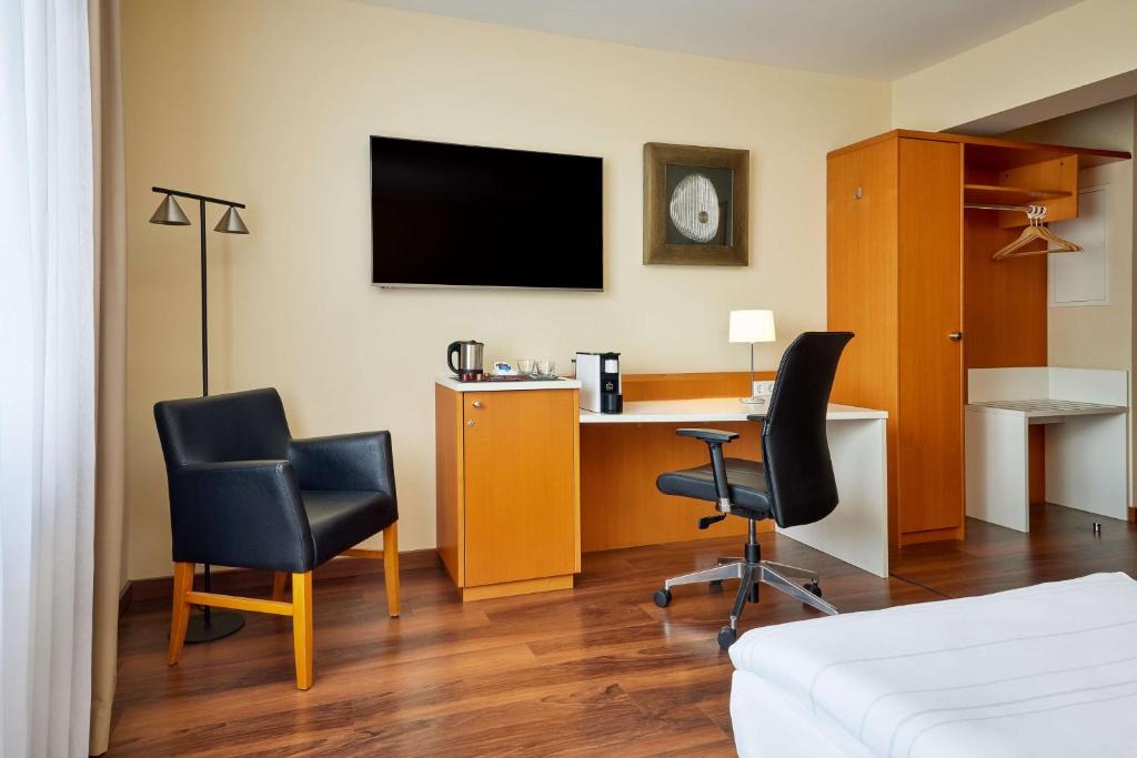 德累斯顿德勒斯顿贝斯特韦斯特马克雷登酒店的客房设有书桌、两把椅子和电视。