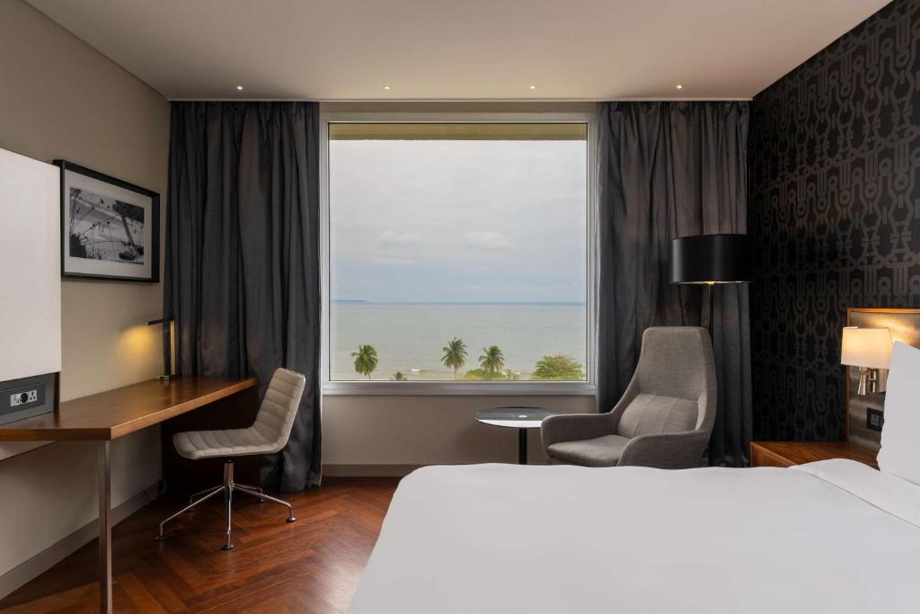 利伯维尔利伯维尔奥古曼皇宫丽笙酒店的配有一张床、一张书桌和一扇窗户的酒店客房