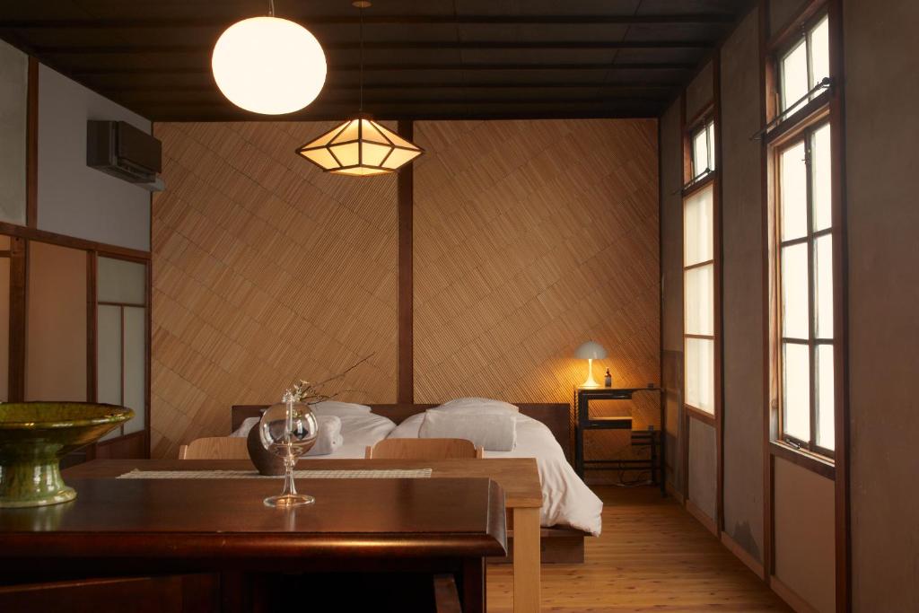 Tamba-sasayamaLhotel de Mai的卧室配有床、桌子和窗户。