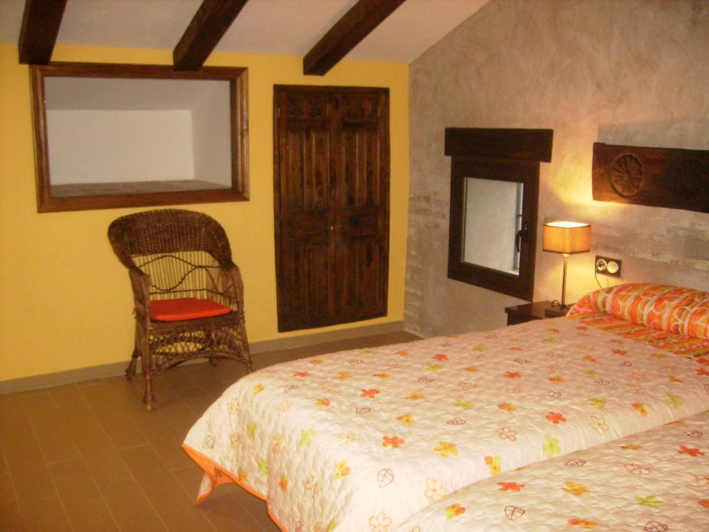 卡索拉Torre Del Inquisidor的卧室配有床、椅子和窗户。