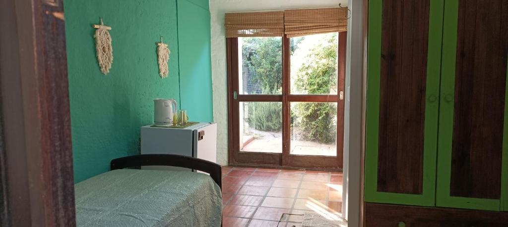 埃尔皮纳尔Hostal Pino Alto的一间设有一张床的房间和一扇带窗户的门