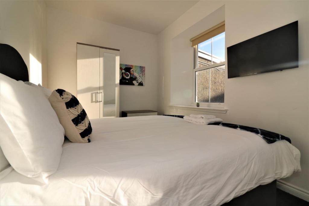 拉纳克Signature - No 1 Bonnet Apartments的卧室设有一张白色大床和一扇窗户。