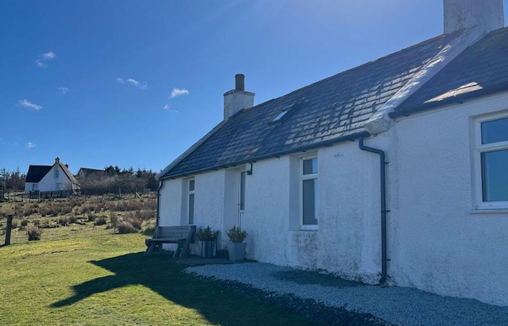 CulnacnocTaigh Mhurdaidh的前面有长凳的白色房子