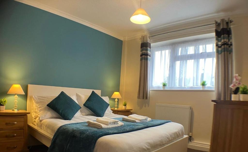 布杰斯希尔Sawyers Lodge的一间卧室配有一张蓝色墙壁的床和一扇窗户