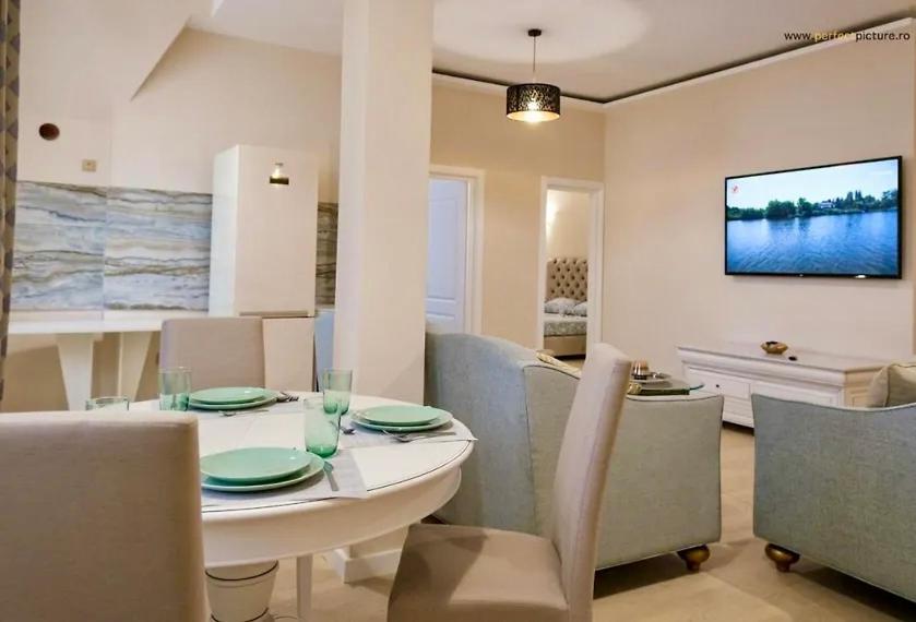 康斯坦察Next Apartments Constanta的一间配备有白色桌椅的用餐室