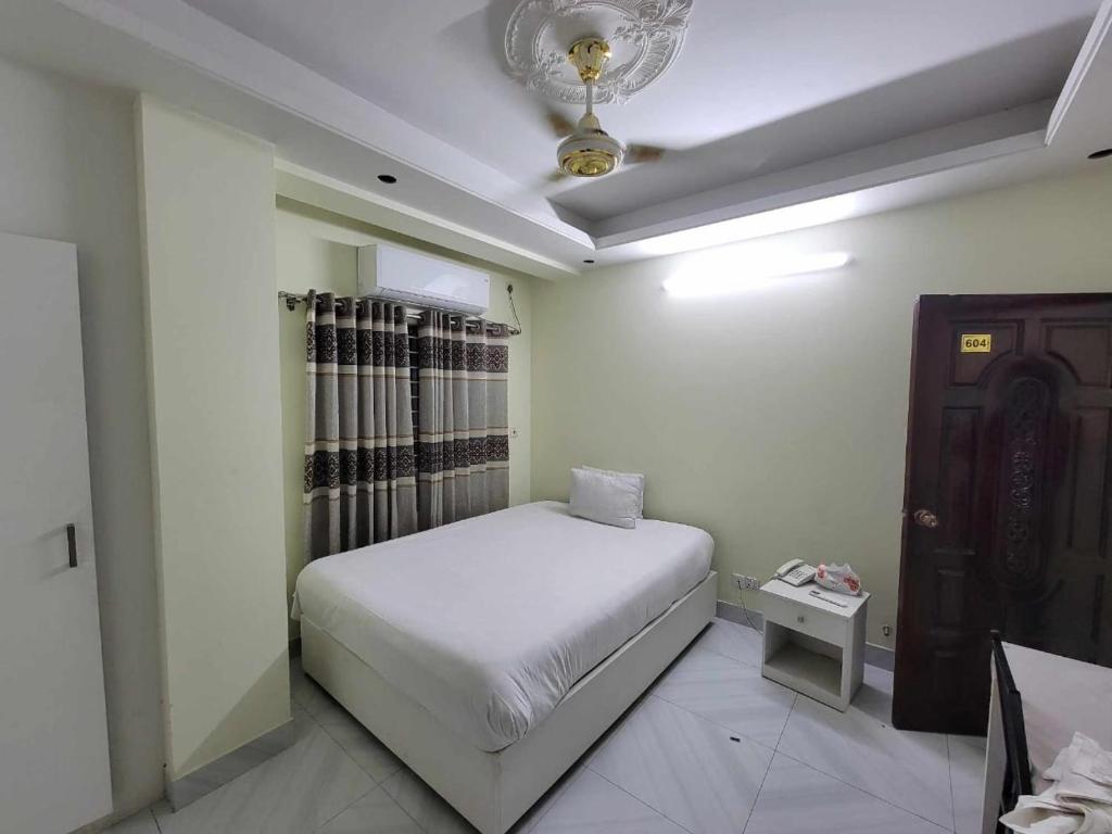 达卡Hotel White Stone的卧室配有白色的床和天花板