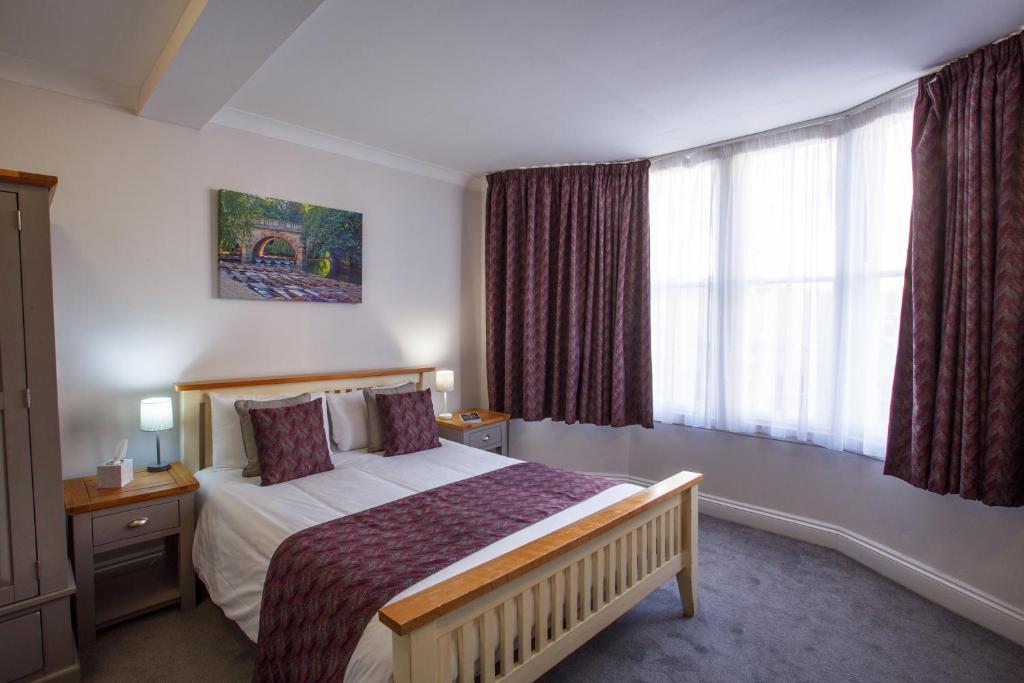牛津巴特利酒店的一间卧室设有一张床和一个大窗户