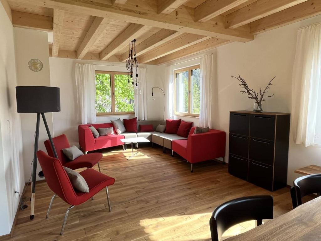 拜尔斯布龙Ferienhaus Baiersbronn LUG INS TAL的客厅配有红色椅子和沙发