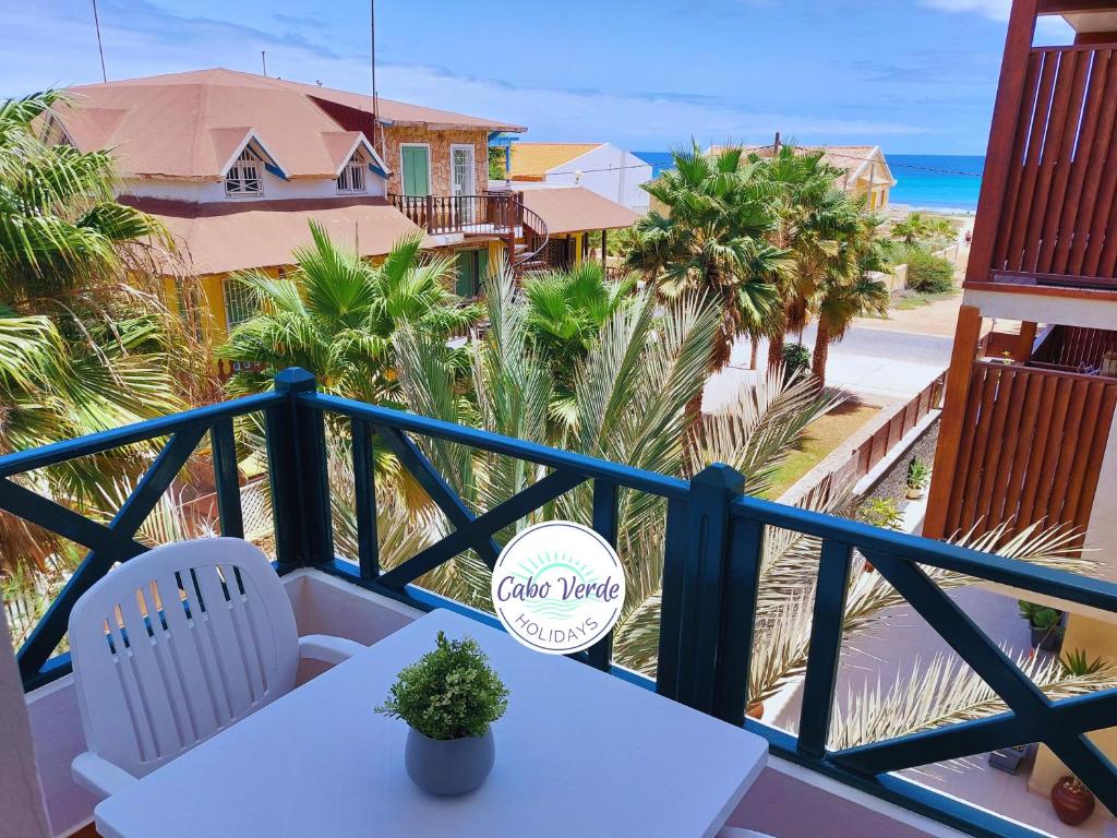 圣玛丽亚Branco Sea Holiday Apartments的一个带桌椅和海滩的阳台