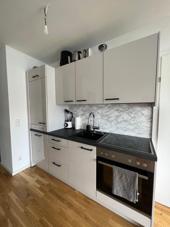 维也纳Modernes & stillvolles Apartment的厨房配有白色橱柜和水槽