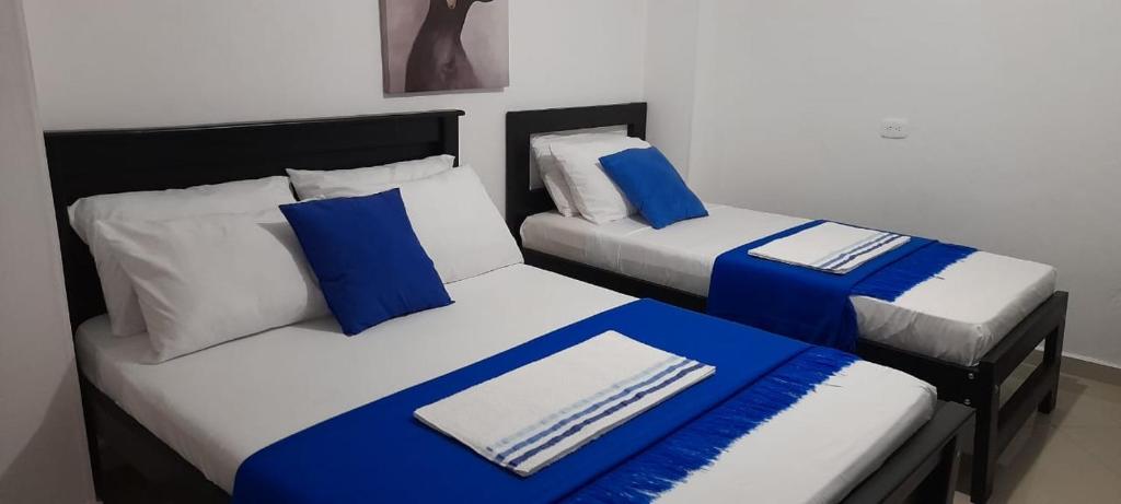 里奥阿查Hotel La Guajira - Centro Historico的两张带蓝色和白色枕头的床