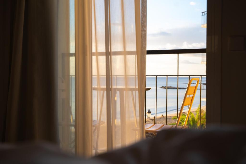圣埃乌拉利亚Boutique Apartments Marsol Ibiza的享有海滩景致的窗户和椅子