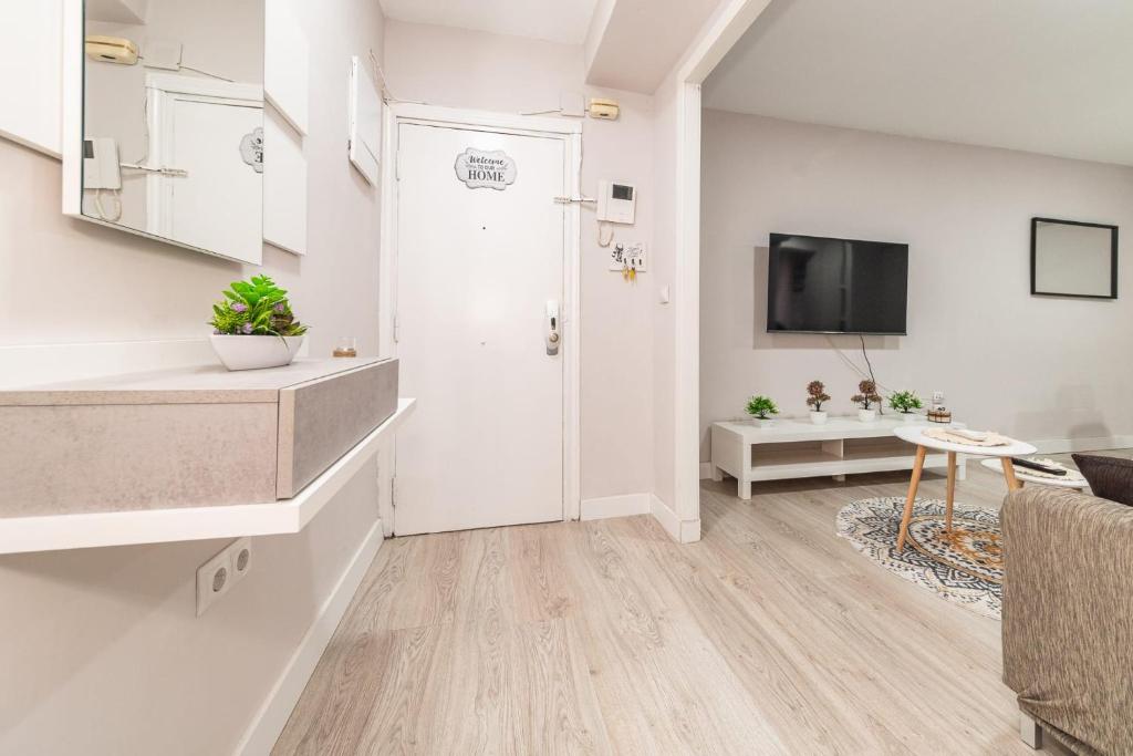 马德里Elegant 6 pax apartment in Plaza Eliptica - SM17的客厅设有白色门和电视。