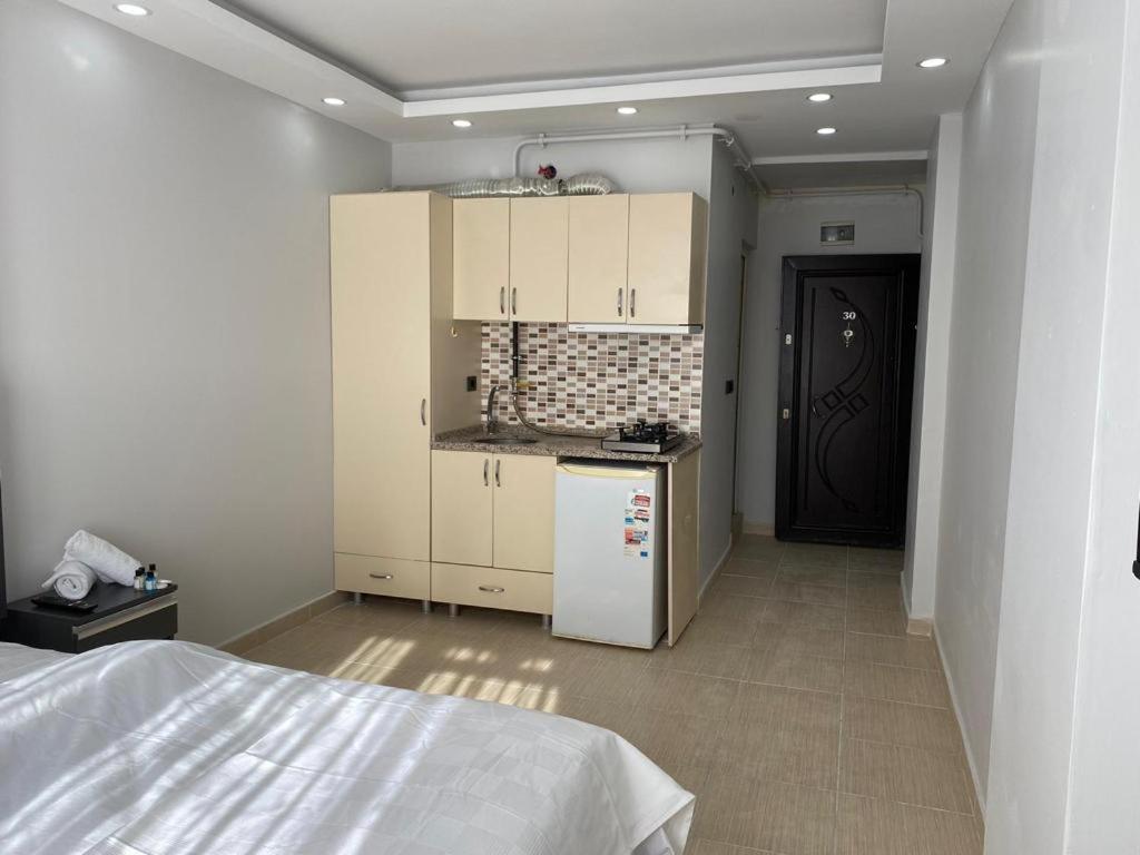 埃迪尔内HERMES OTEL的厨房配有白色橱柜和白色冰箱。