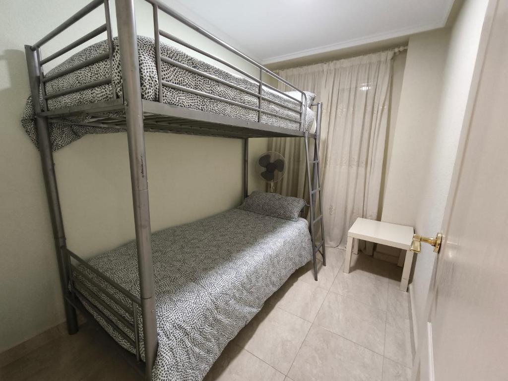 托雷维耶哈Beach and sun guest house的一间卧室配有一张双层床和一张桌子