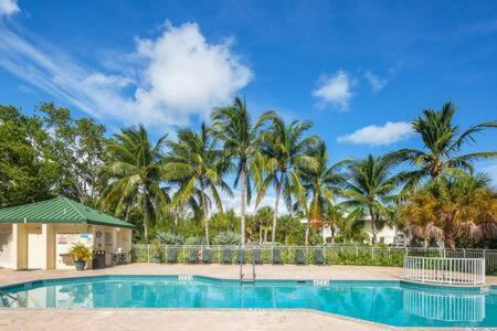 基韦斯特NEW Grenada Suite - Parking Pool & Pets 209的一座棕榈树环绕的游泳池