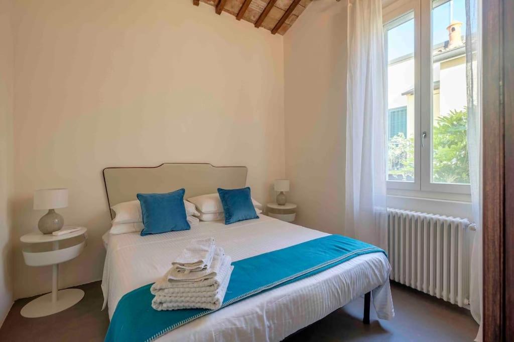 拉文纳La Casetta nel Cerchio的一间卧室配有一张带蓝色枕头的床和一扇窗户。