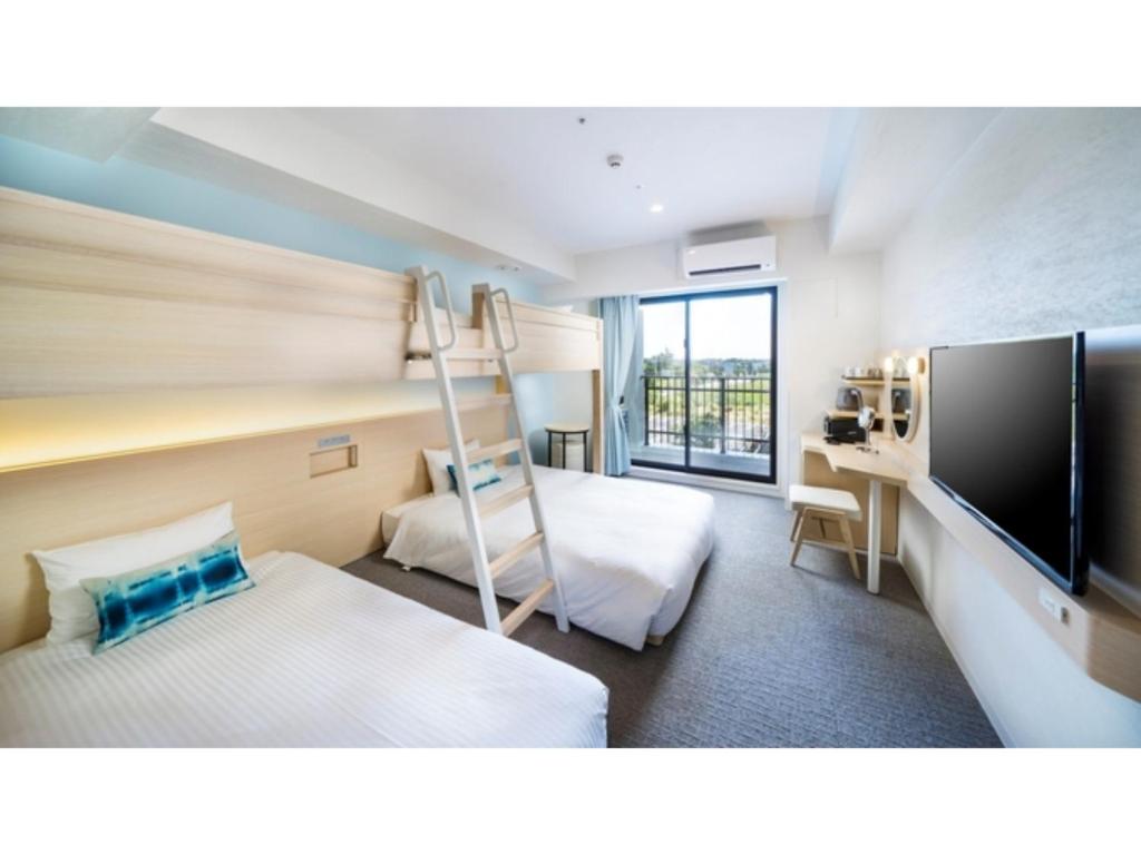 宫古岛Hotel Torifito Miyakojima Resort - Vacation STAY 79485v的酒店客房配有双层床和电视。
