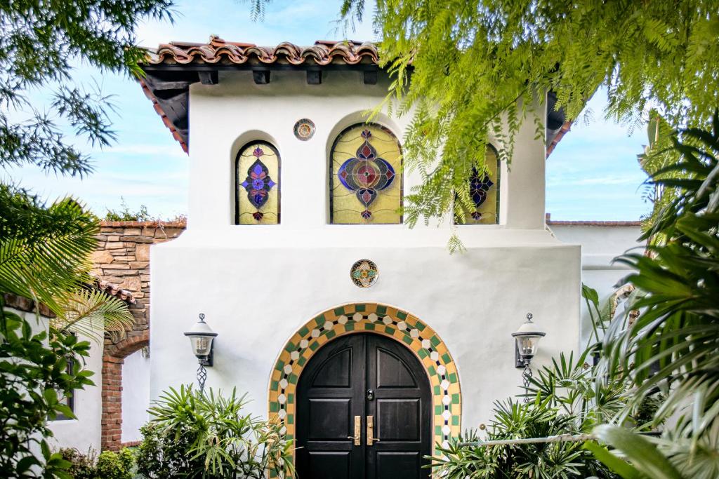 棕榈泉Lucille Palm Springs的一座带黑色门和彩色玻璃窗的房子