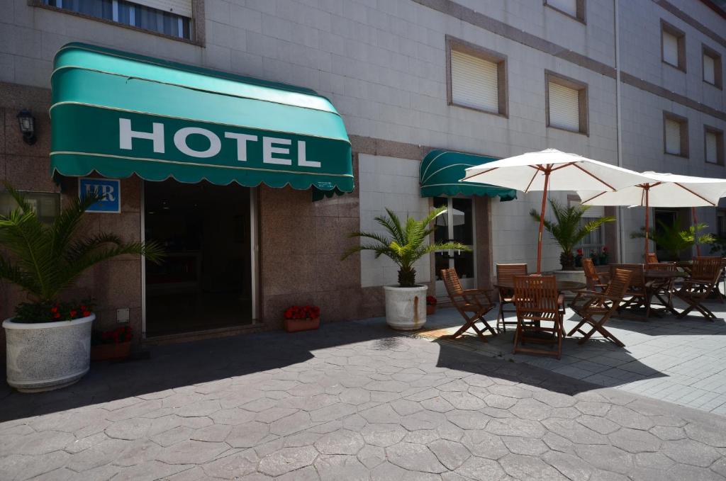 桑亨霍拜萨斯酒店的外面设有桌子和遮阳伞的酒店