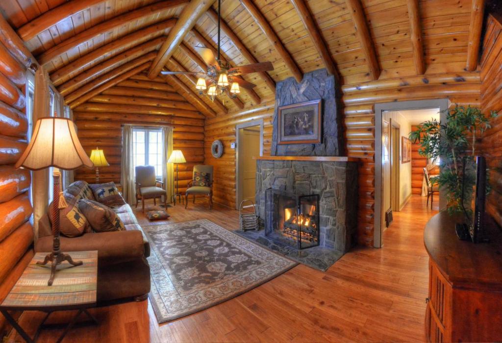 拉皮德城Historic Log Cabin #14 at Horse Creek Resort的小木屋内带壁炉的客厅