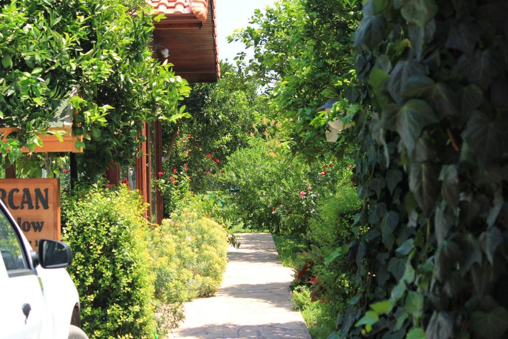 契拉勒Mercan Bungalow的一条有灌木和树木的花园小径和一座建筑
