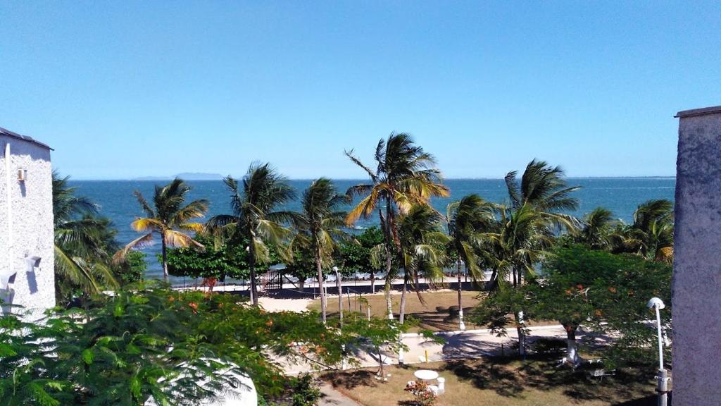 大伊瓜巴Morada do Sol de Iguaba AP 2 qts的享有棕榈树海滩和大海的景色