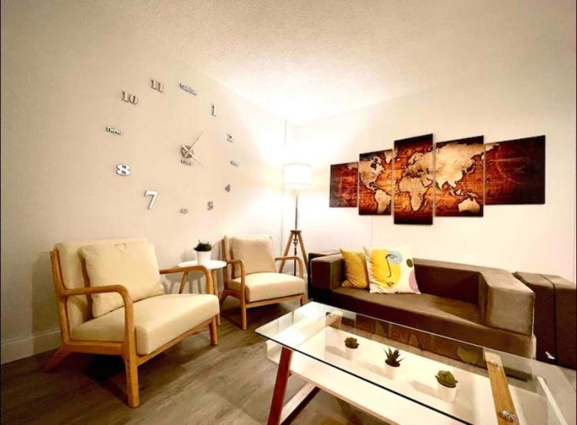 迈阿密Miami International Airport 1的客厅配有沙发和墙上的时钟