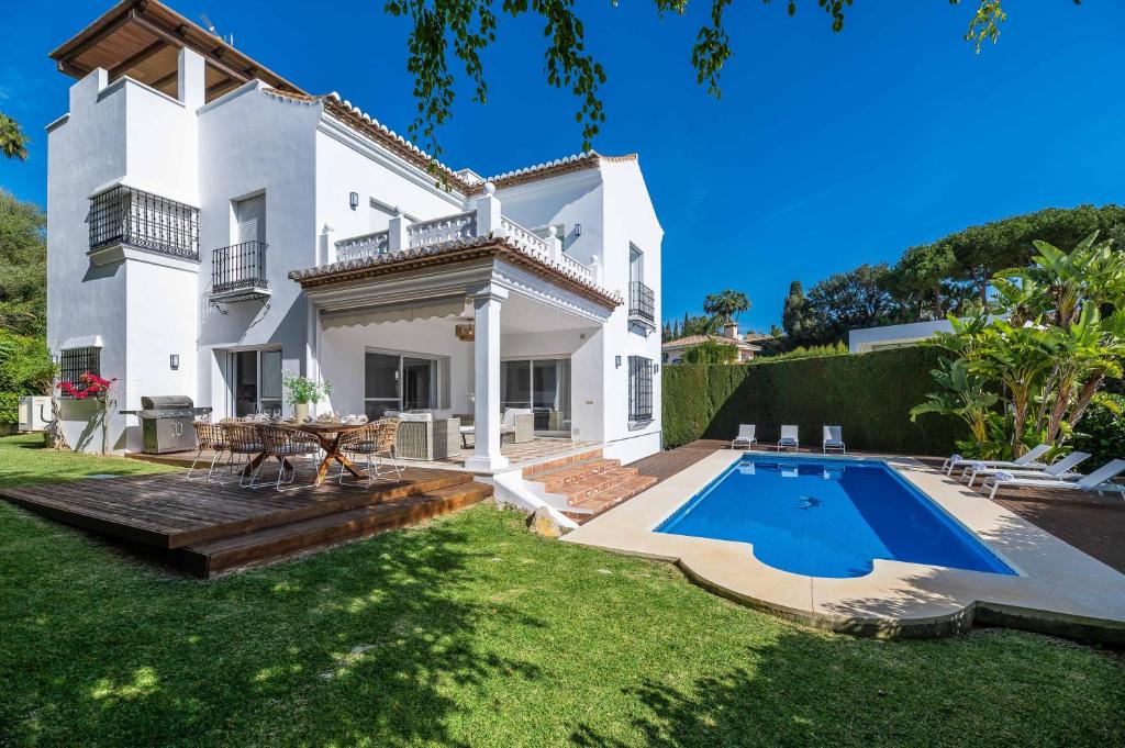 马贝拉VACATION MARBELLA I Villa Nadal, Private Pool, Lush Garden, Best Beaches at Your Doorstep的一座白色的房子,在庭院里设有一个游泳池