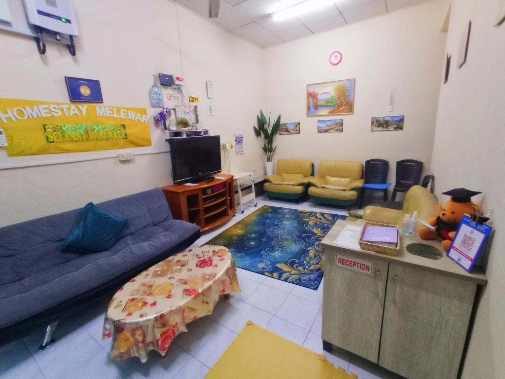 巴力拉惹Homestay Melewar的一间配备有蓝色沙发和电视的等候室