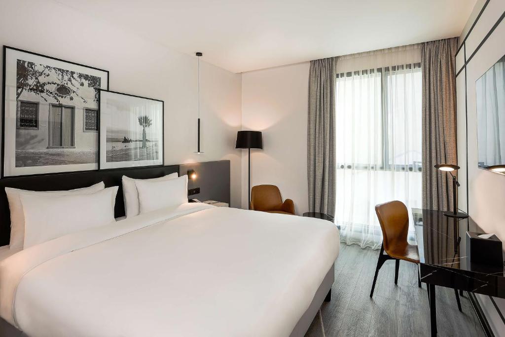 突尼斯Radisson Hotel Tunis, City Center的一张大白色的床,位于酒店客房内