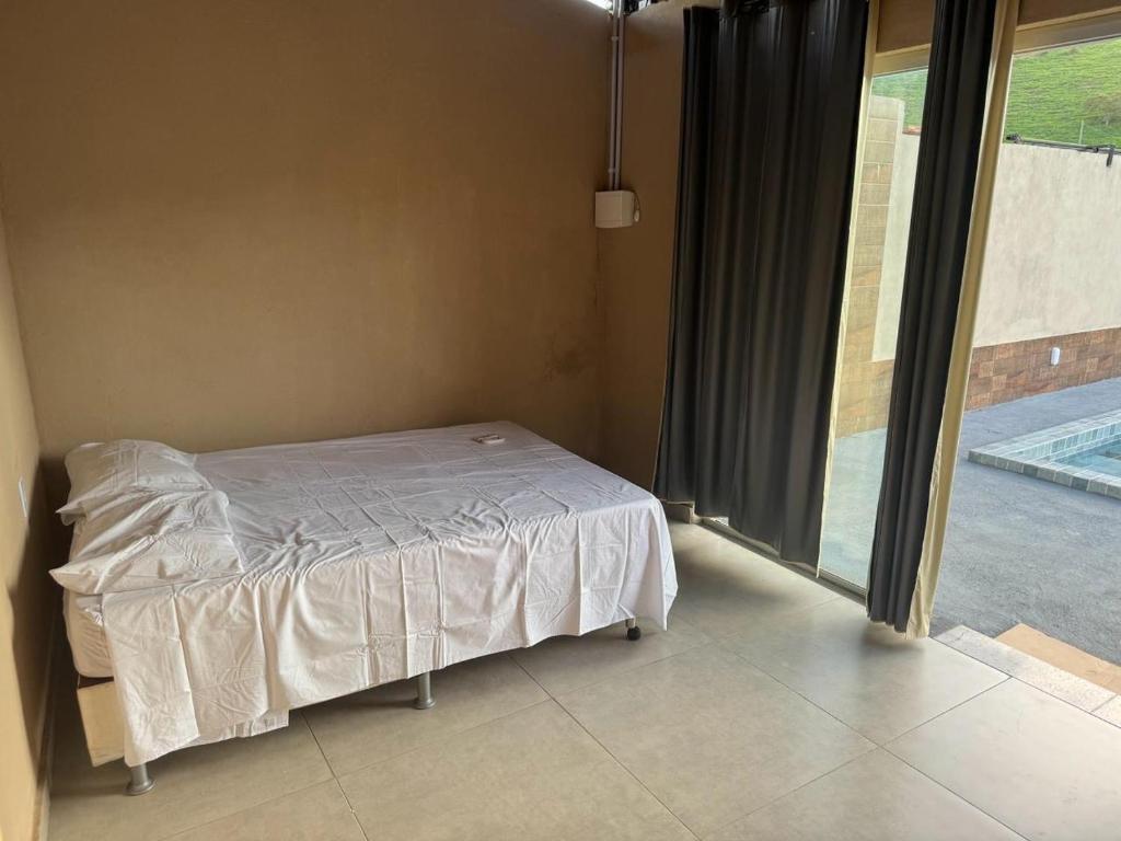 Raul SoaresCantinho da Alegria的一间卧室设有一张床和一个大窗户