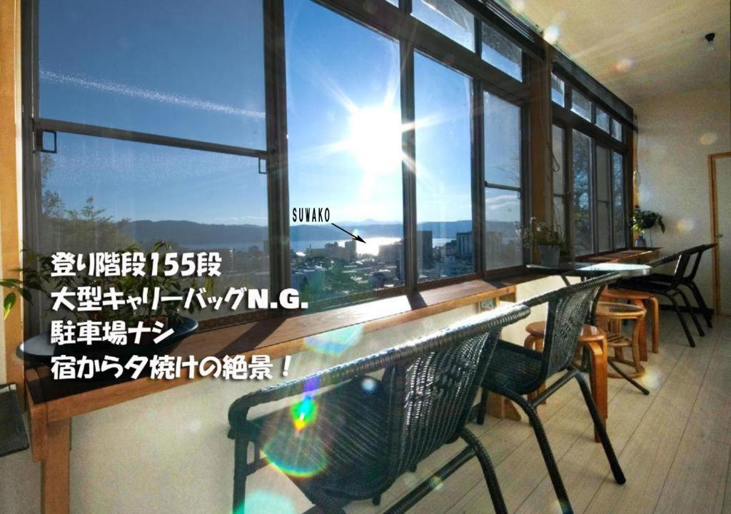 诹访市榻榻米旅馆的客房设有桌子和享有美景的窗户。