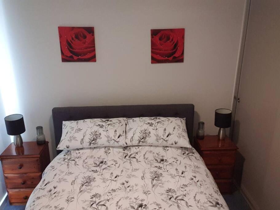 索雷尔港Shore beats working的卧室配有一张墙上有两张照片的床。