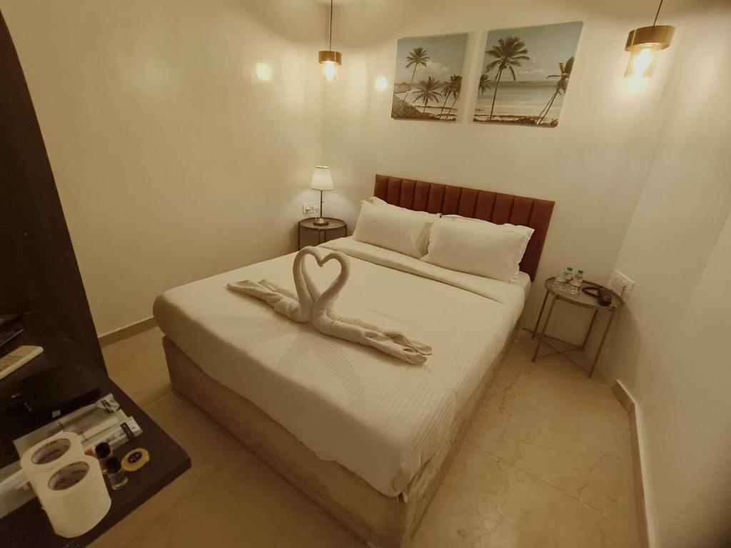 孟买The Majlis Hotel - Colaba Mumbai的一间卧室配有一张床,拥有心灵装饰