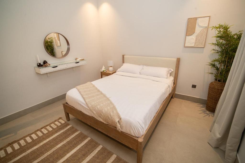 利雅德SAQEEFA 9 - A01 - Self Entrance的一间卧室配有一张带白色床单和镜子的床